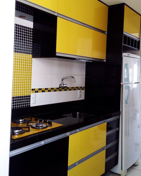 Contraste entre armário de cozinha preto e amarelo e azulejos de parede
